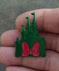 Green castle enamel pin with three spires and pink bow center detail