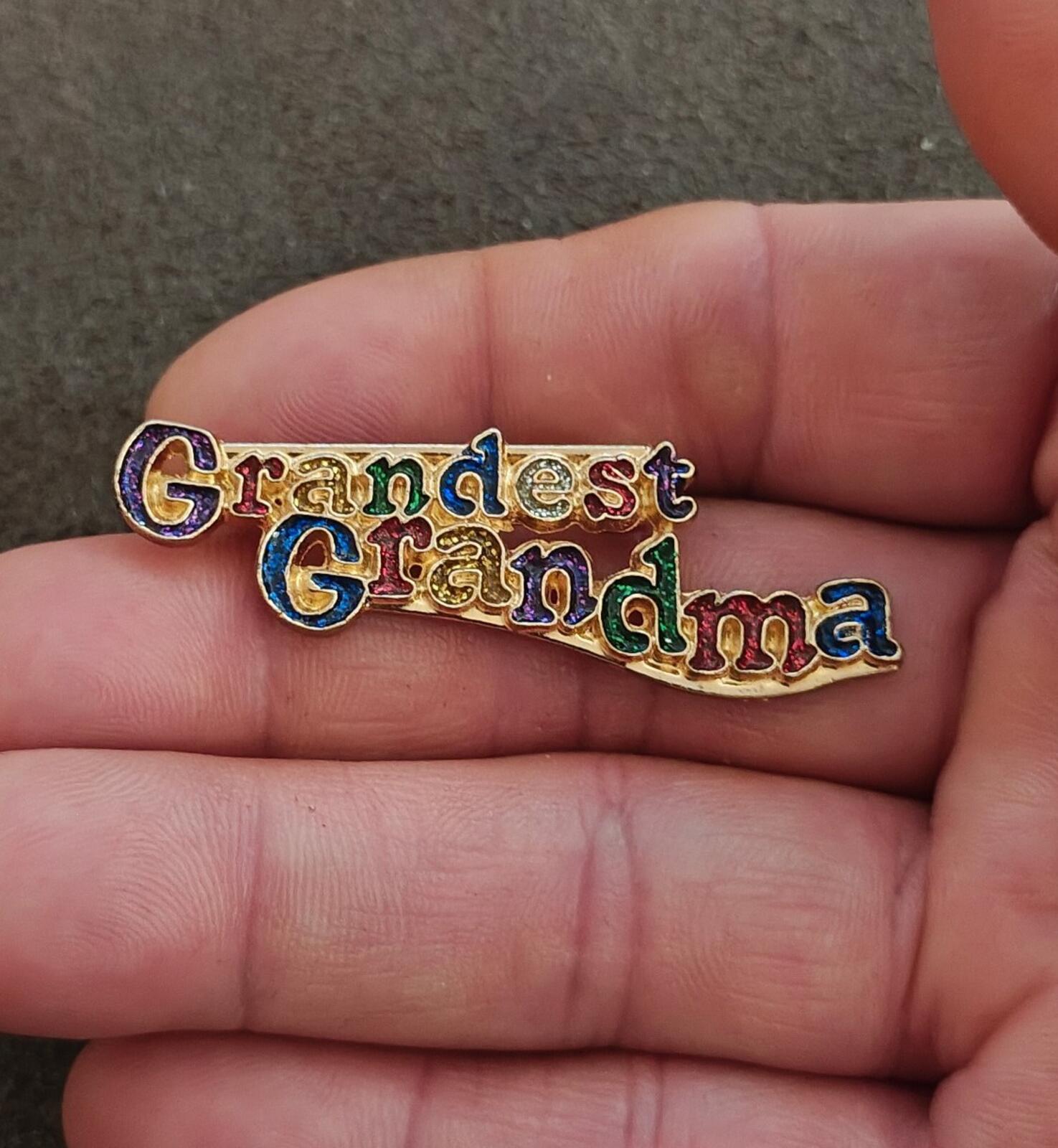 Grandma enamel brooch held in hand, colorful 'Grandest Grandma' lettering