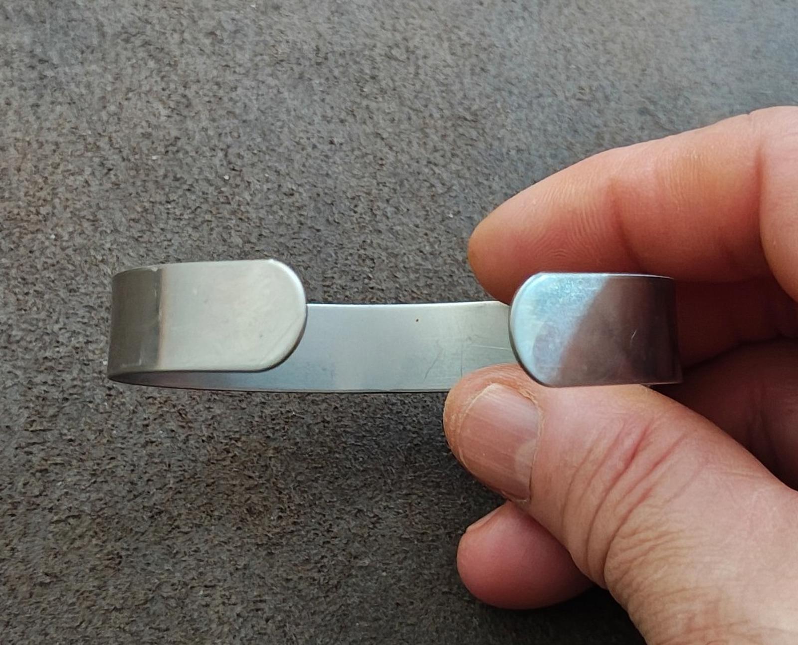 Silver tone open cuff bracelet with rounded ends and smooth interior