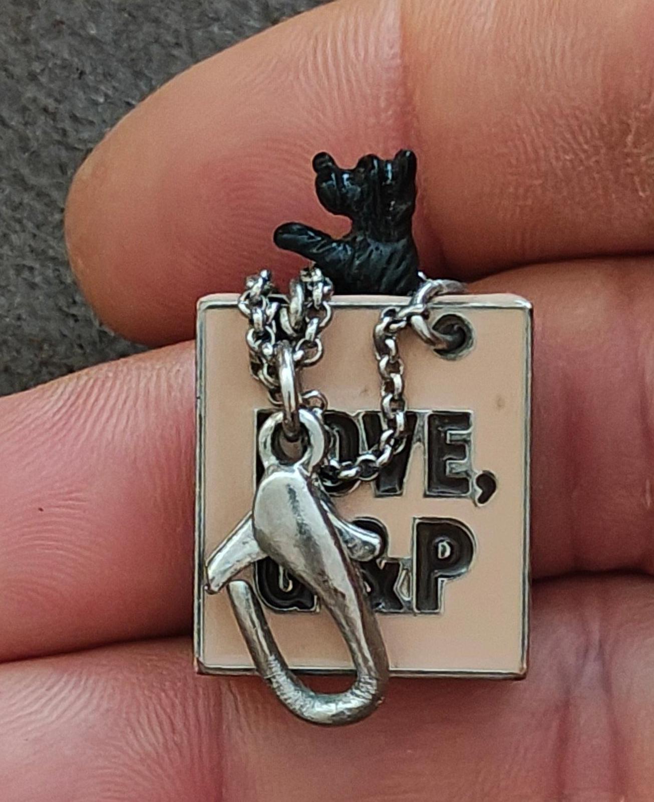 Juicy Couture bag charm showing "LOVE, G&P" square tag and dog silhouette