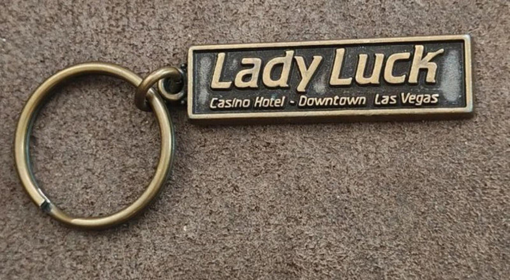 Gold Lady Luck casino hotel keychain with engraved rectangular badge and key ring