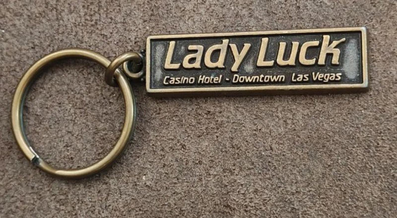 Gold Lady Luck casino hotel keychain with engraved rectangular badge and key ring