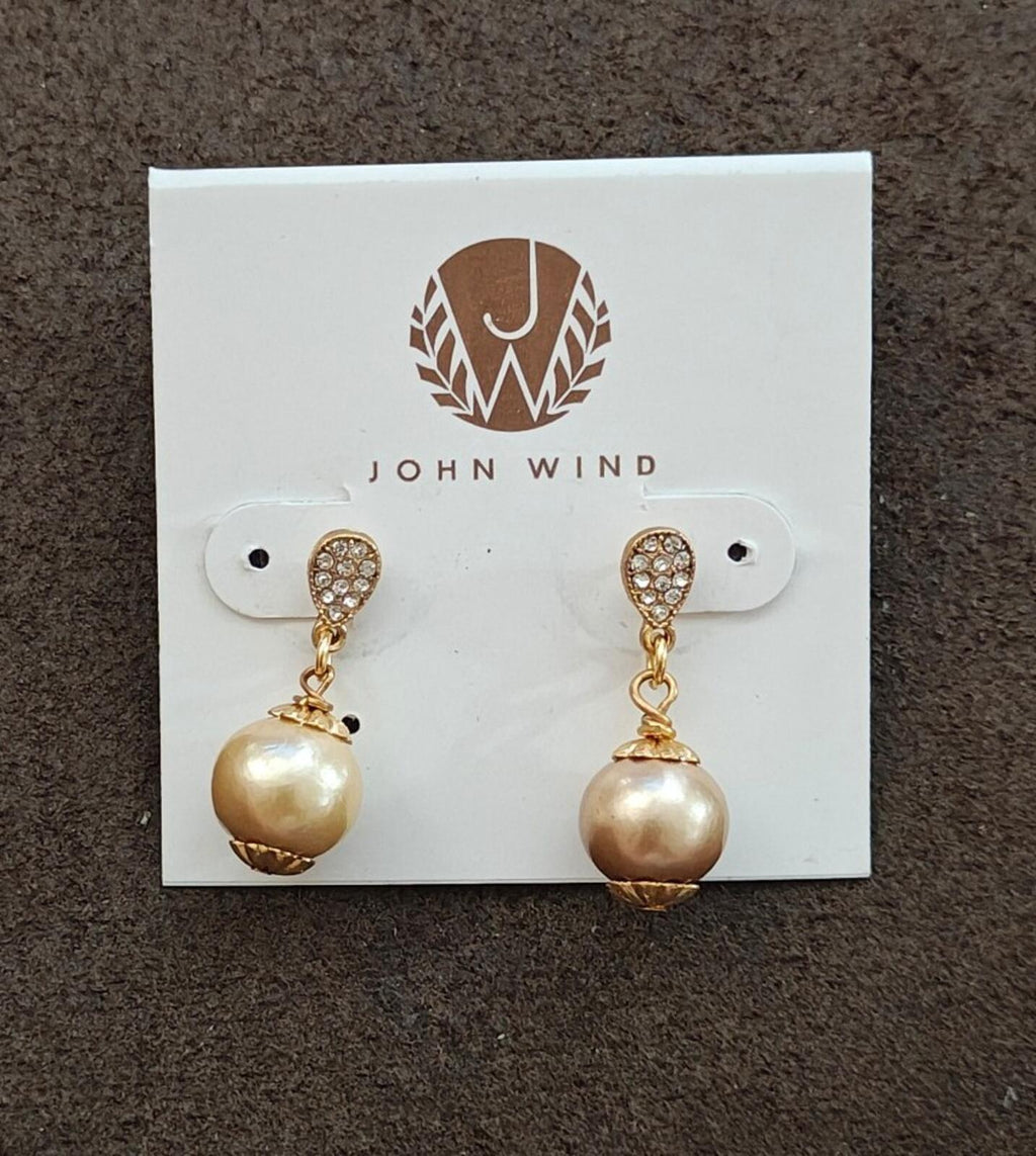 Gold tone drop earrings featuring crystal-like caps and round pearl-like center beads