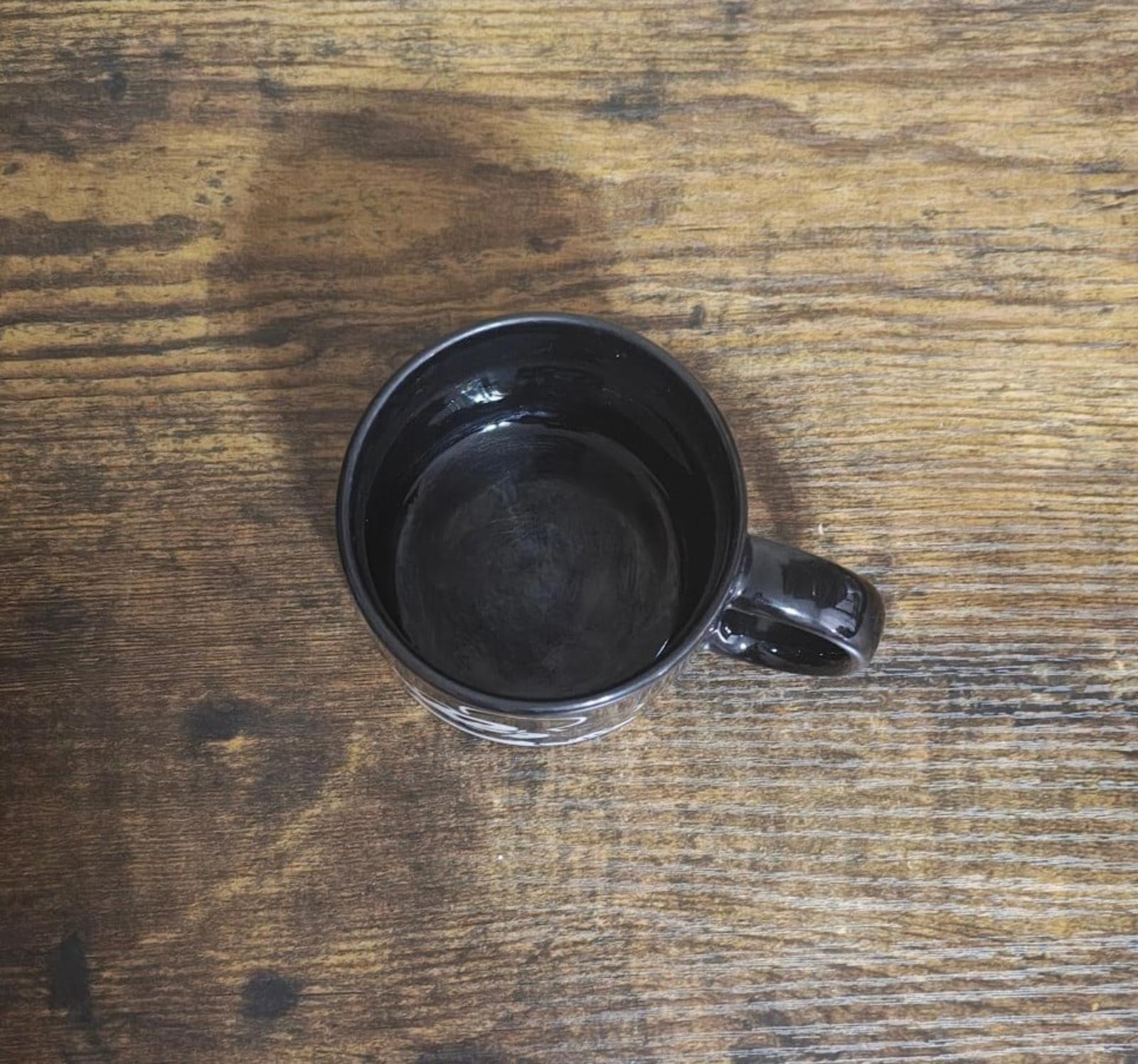 Bottom view of black mug with glossy interior and black handle