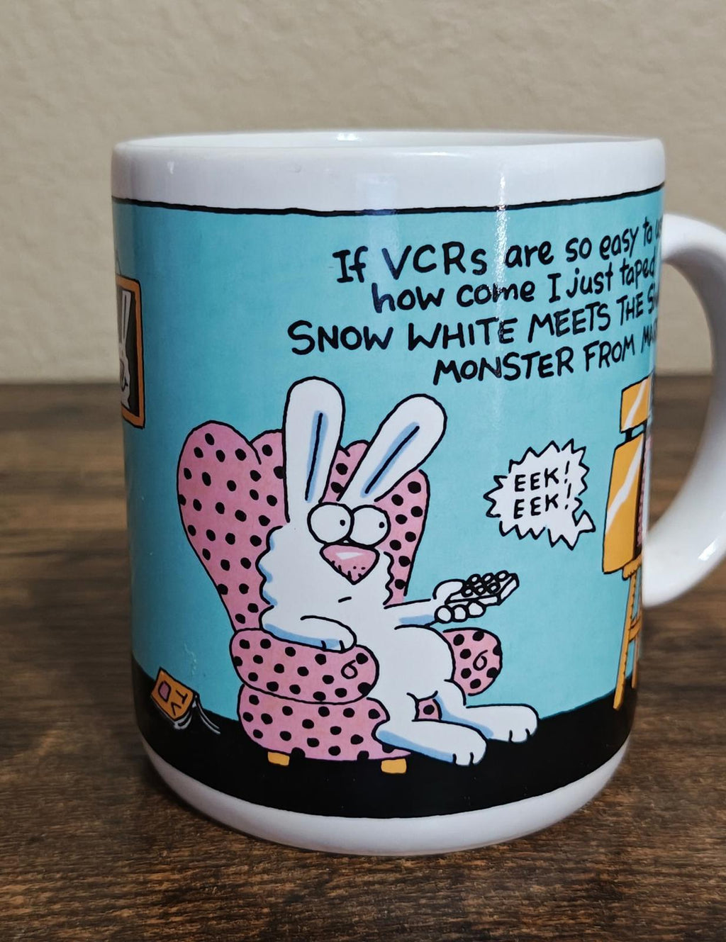 Blue ceramic mug front showing cartoon rabbits and VCR joke text