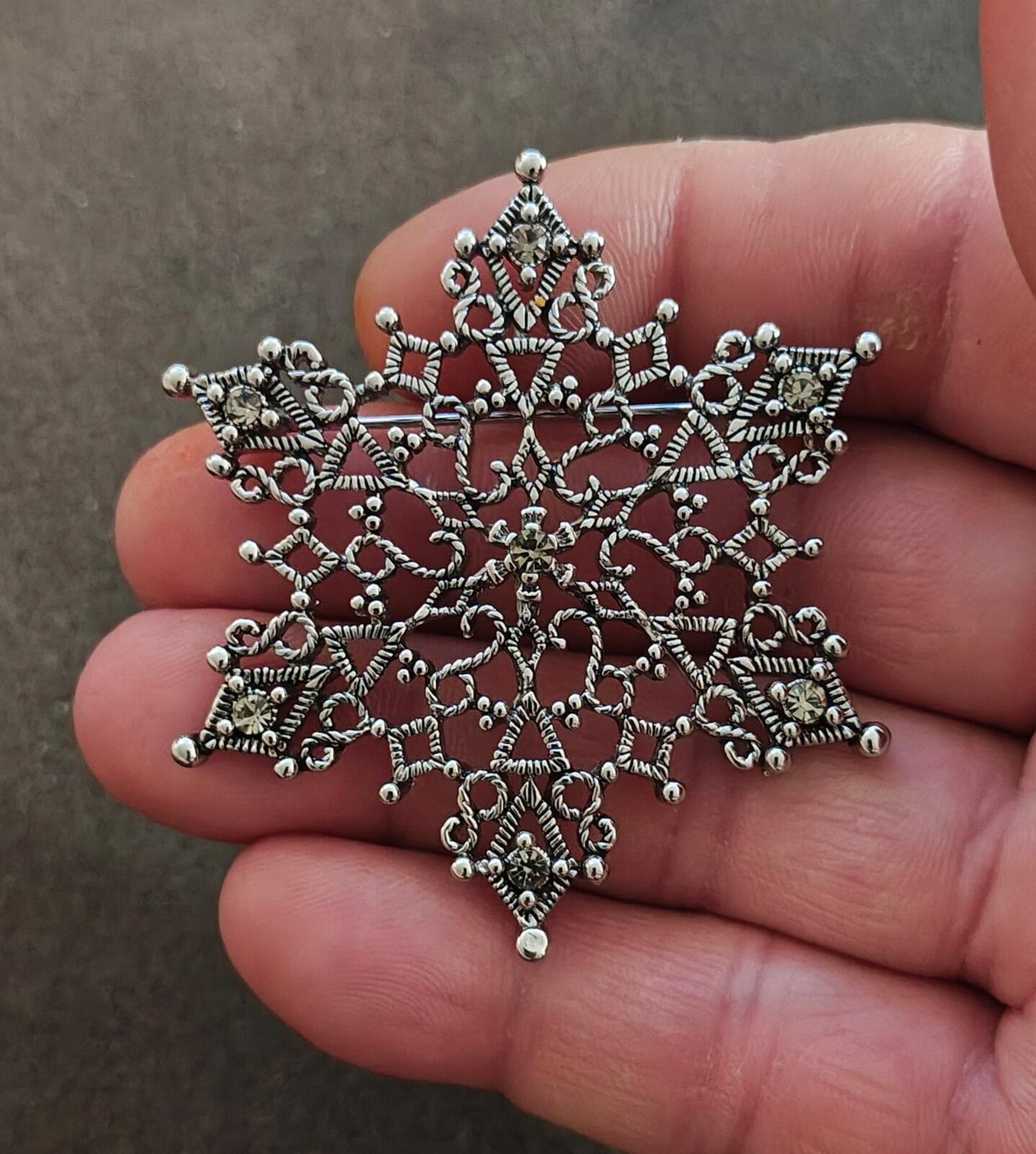 1990s Silver Tone Filigree Snowflake With Clear Rhinestone Accents Brooch.