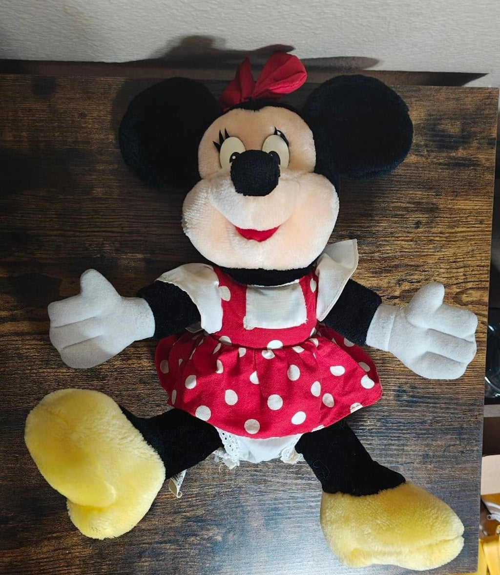 Minnie Mouse plush smiling with outstretched arms, red polka-dot dress, yellow feet