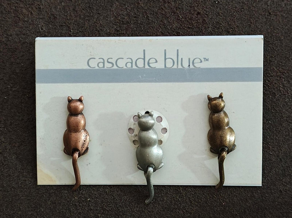 Set of three cat pins on cascade blue card, two bronze cats flanking a silver cat
