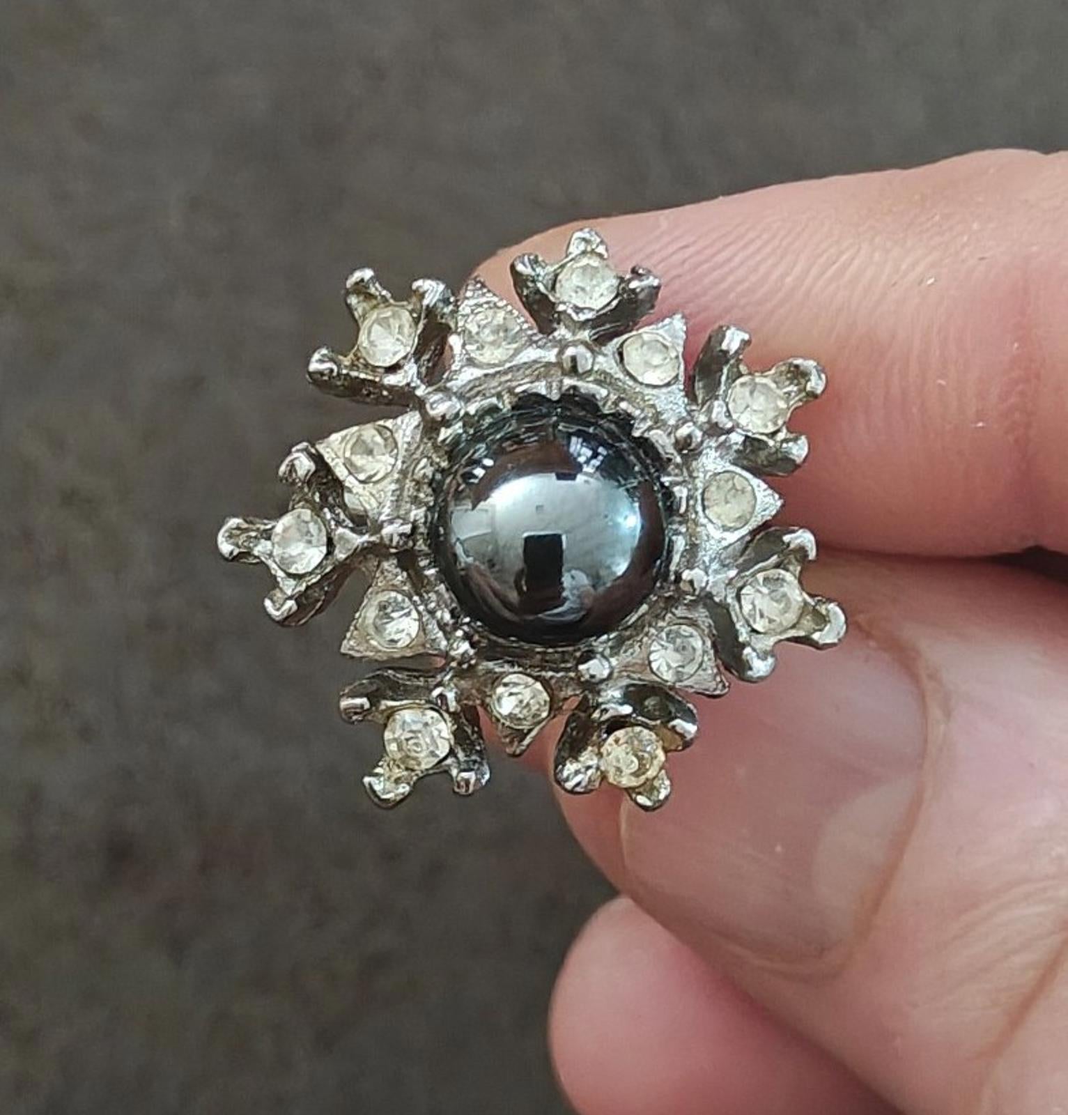 Vintage starburst snowflake ring with silver tone setting and round dark hematite center