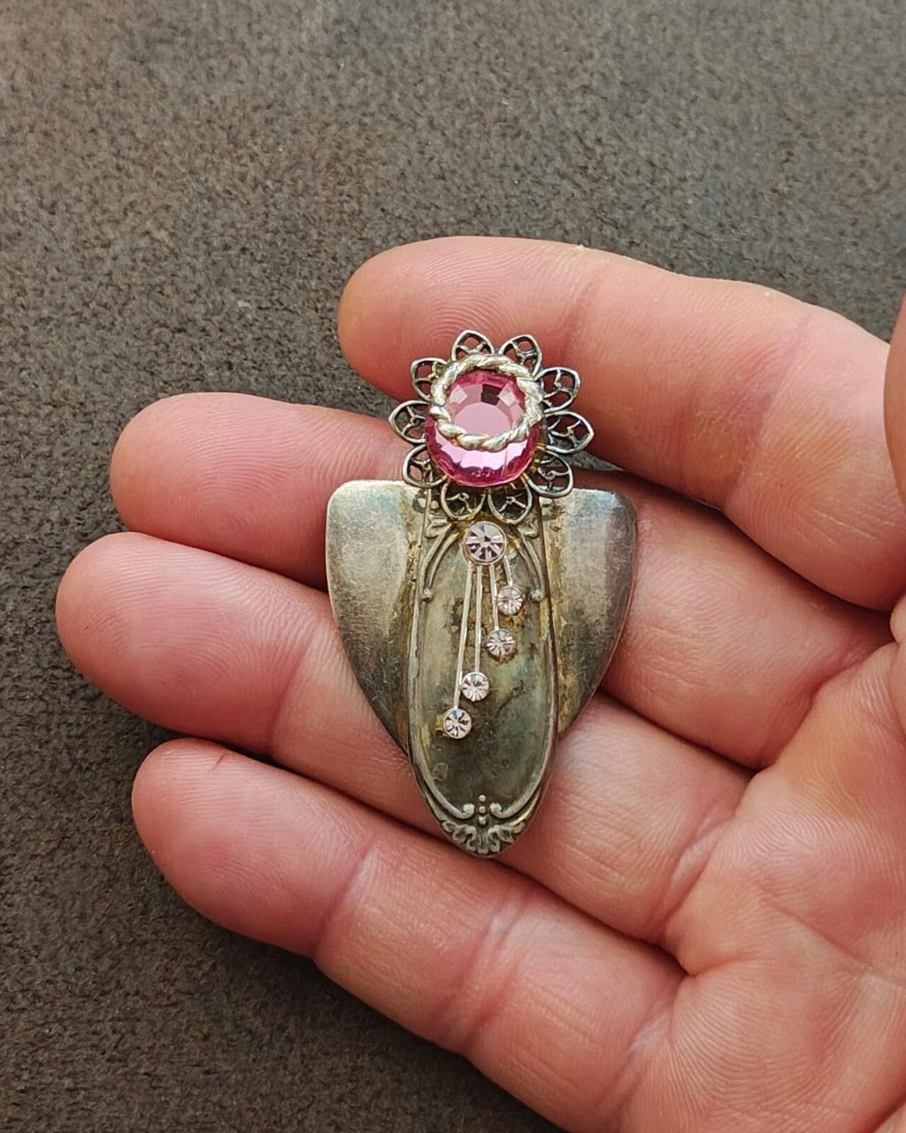 Silver tone angel brooch on hand, pink center rhinestone with multiple clear drops