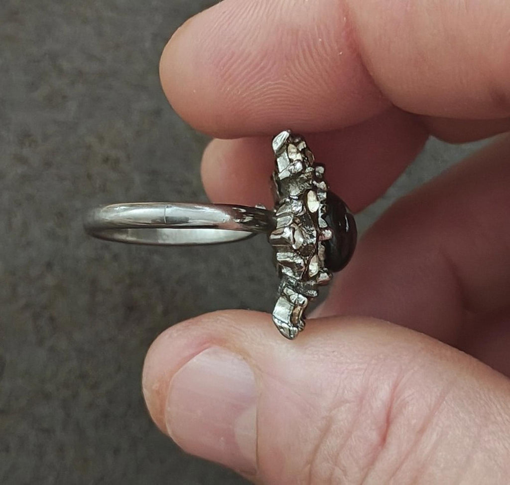 Vintage silver tone ring featuring a snowflake starburst crown around a dark center stone