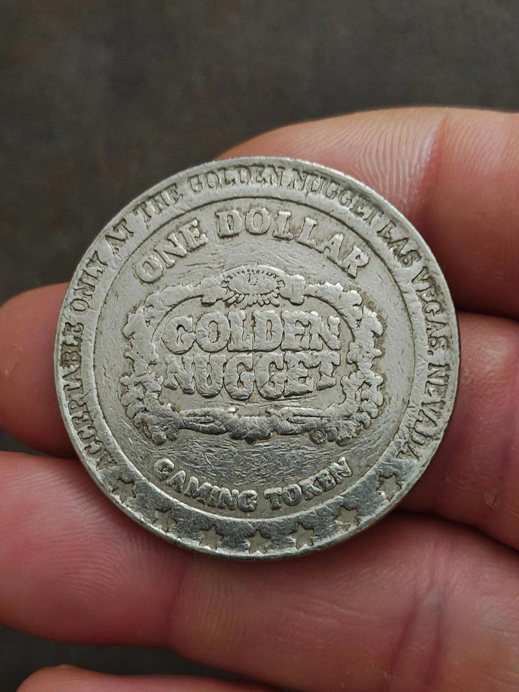 Silver Golden Nugget one-dollar casino token reverse with GOLDEN NUGGET in a wreath.