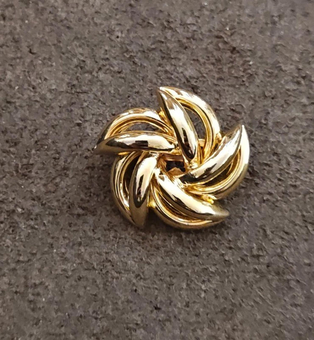 Gold-tone flower brooch, reflective swirl petals on textured surface