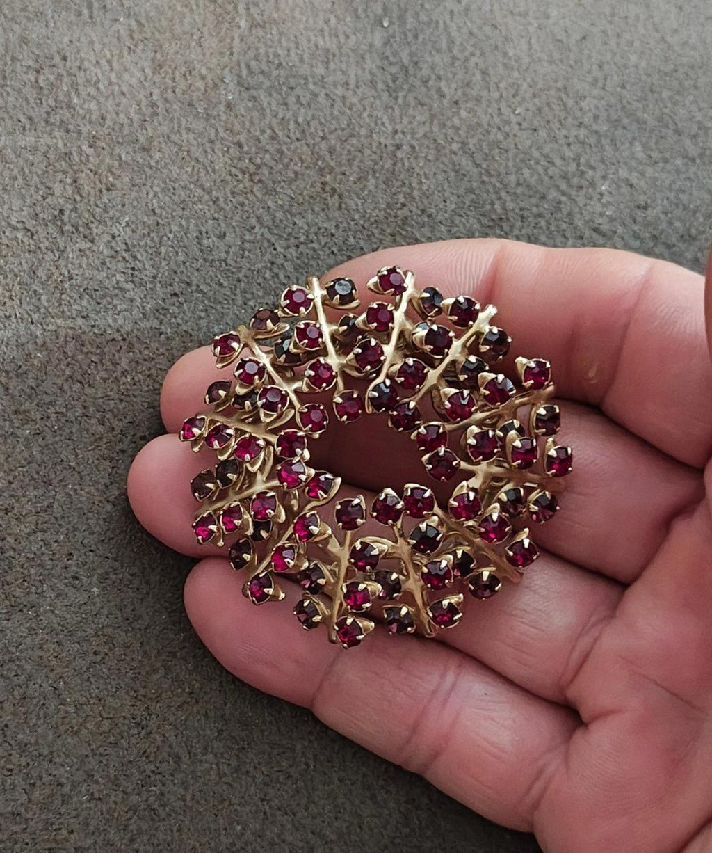 Gold-tone rhinestone brooch pin with maroon and dark stones, oval settings