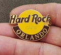 Hard Rock Cafe Orlando gold-tone enamel pin with yellow logo and 'Hard Rock' text