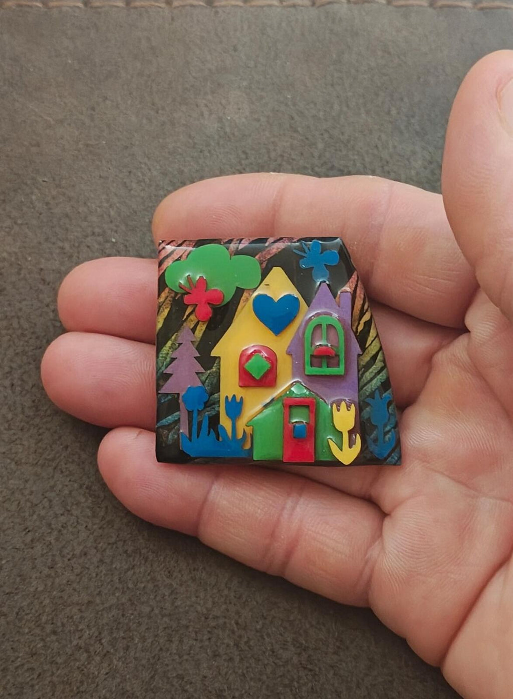 Colorful enamel house design pin with green roof, yellow house, and red doors