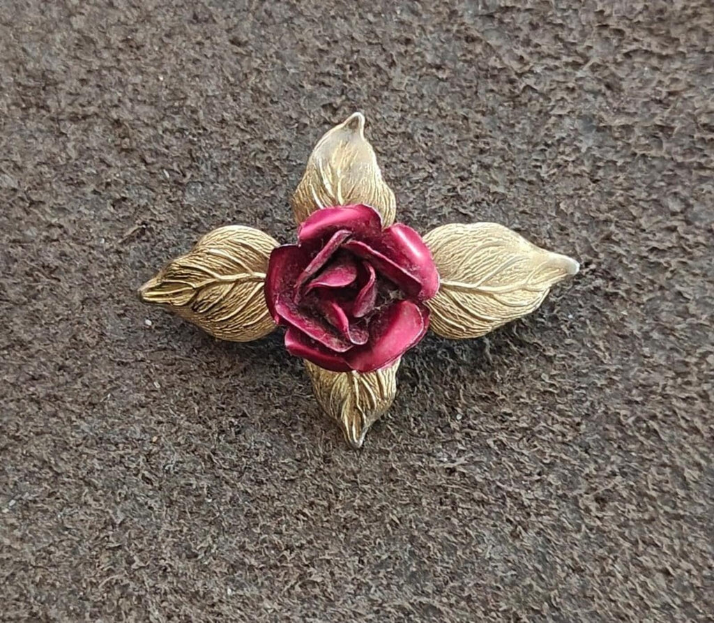Gold-tone rose enamel brooch showing red rose detail and four textured leaves