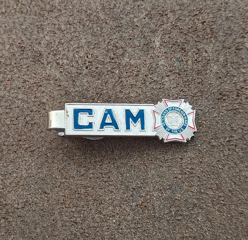 Silver-tone tie bar clip with blue “CAM” lettering and star badge emblem