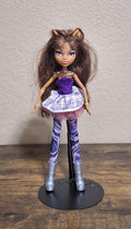 Fashion doll in purple glitter tube top, plaid skirt, and patterned purple leggings