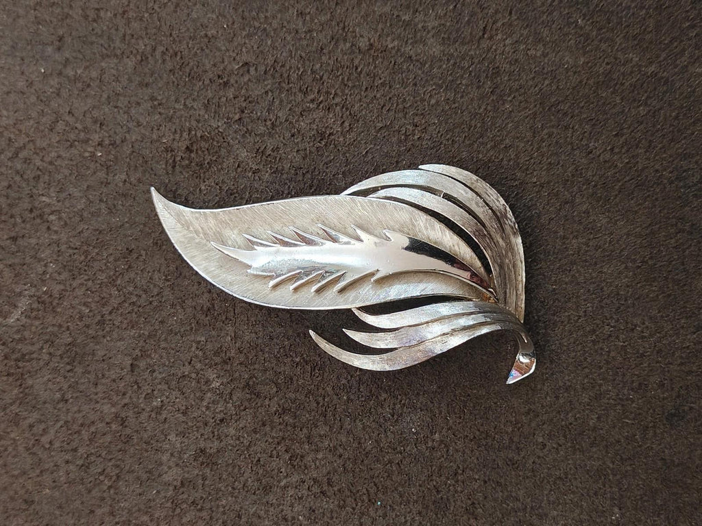 Silver-tone leaf brooch with flowing layered leaves, angled side view