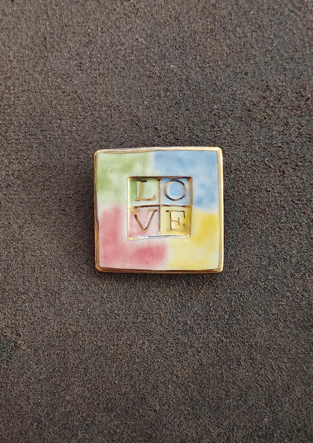 Square polymer clay brooch with 'LOVE' letters on pastel green, blue, pink, yellow