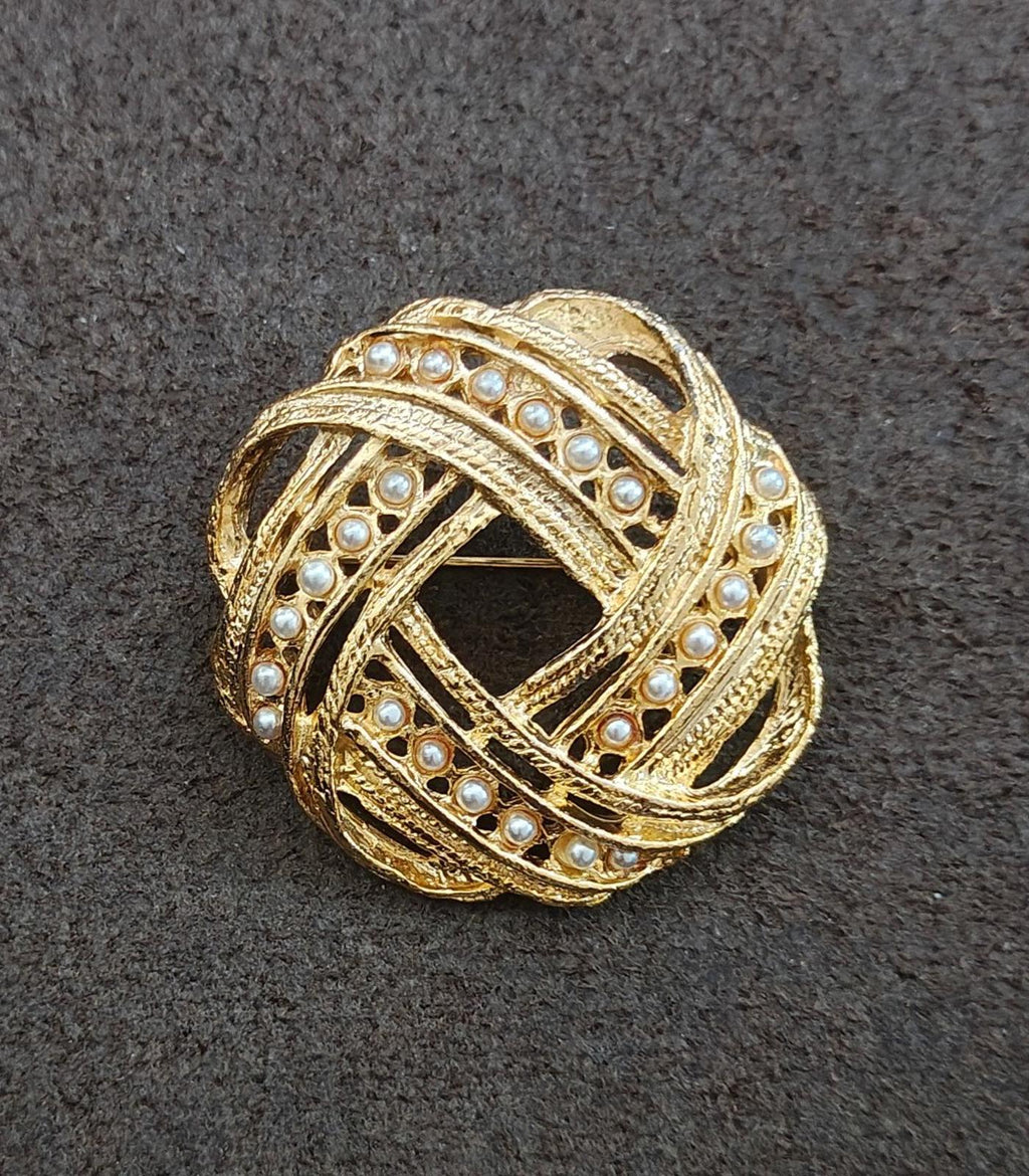 Gold-tone brooch featuring faux pearl rows and decorative filigree lattice