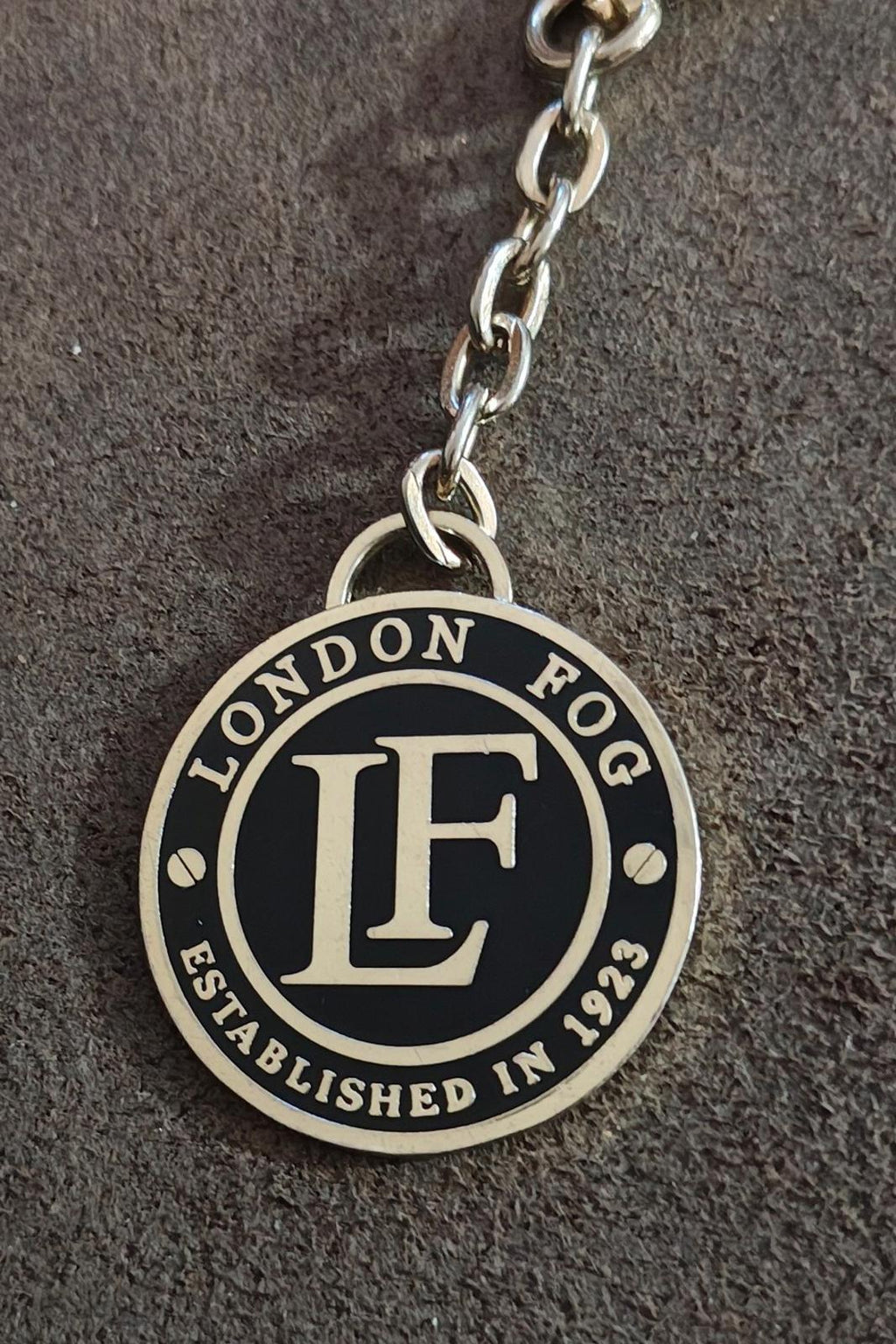 Round black enamel logo charm on a silver-tone chain