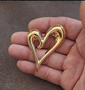 Gold heart-shaped pin with open center, glossy raised design in a V shape