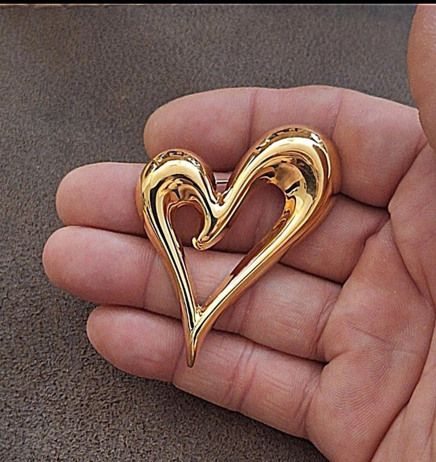 Gold heart-shaped pin with open center, glossy raised design in a V shape