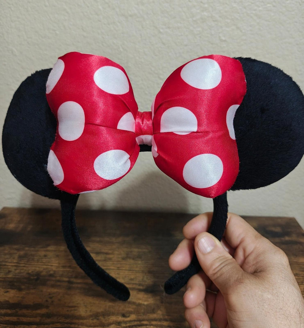 Front view of red and white polka-dot bow ear headband with black fabric ears