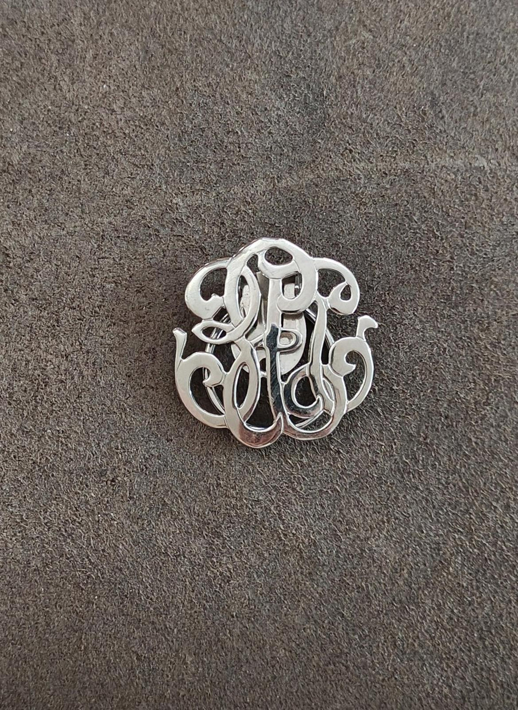 Silver-tone monogram scarf clip, front view of ornate cutout letters