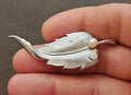 Silver leaf brooch with textured leaf design and a cultured pearl at the center