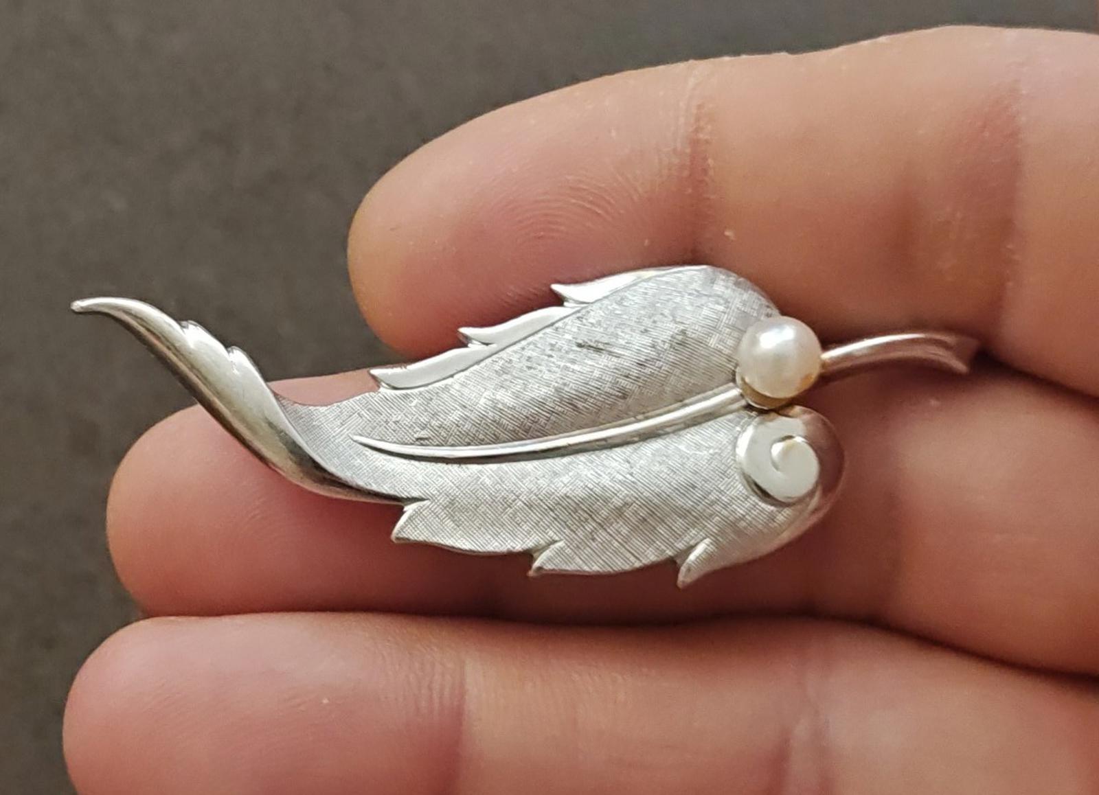 Silver leaf brooch with textured leaf design and a cultured pearl at the center
