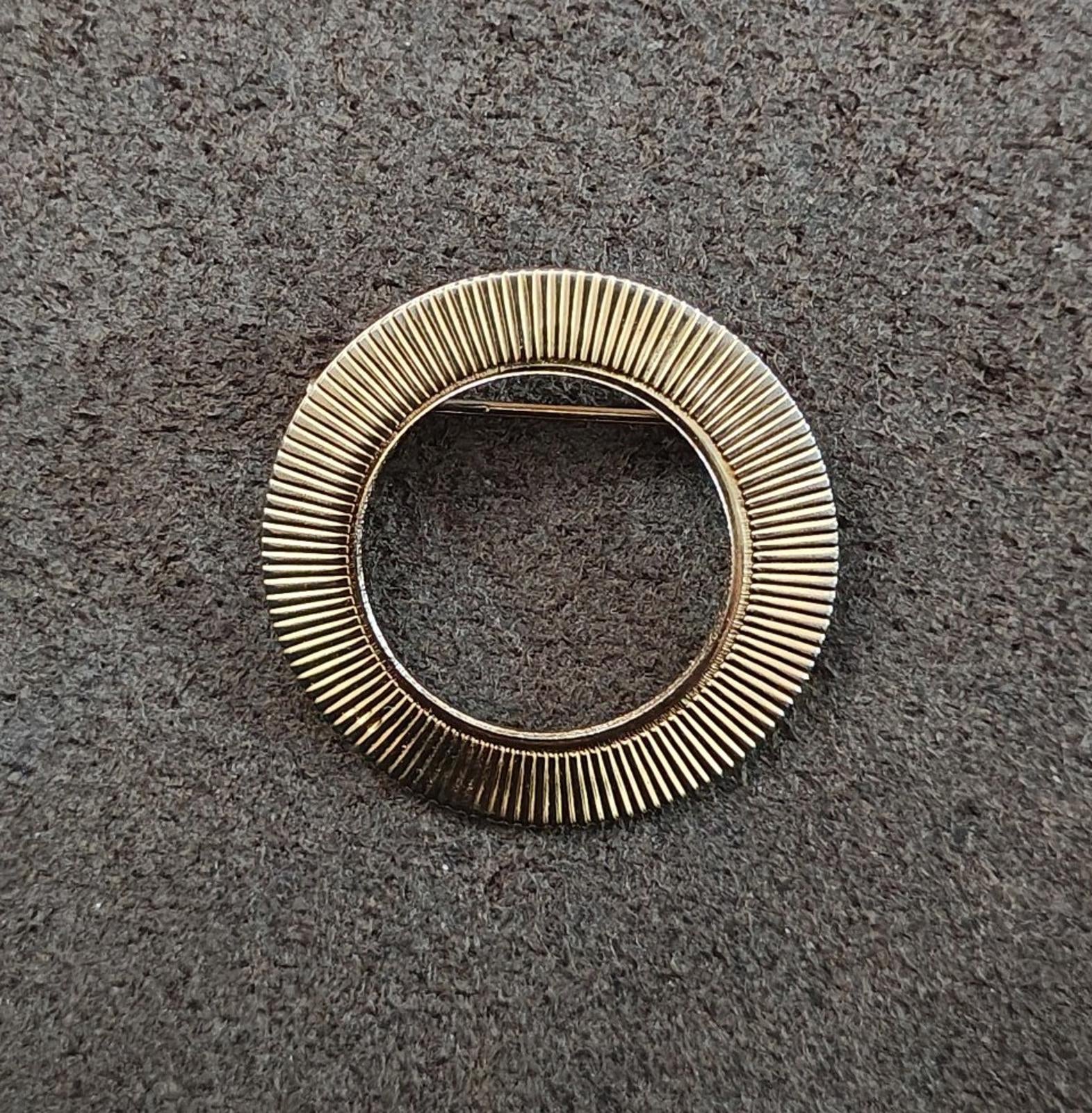 Gold tone ribbed circular openwork brooch pin with inner open ring