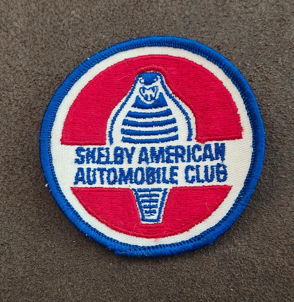 Close-up of 1990s Shelby American Automobile Club patch; blue border and embroidered text