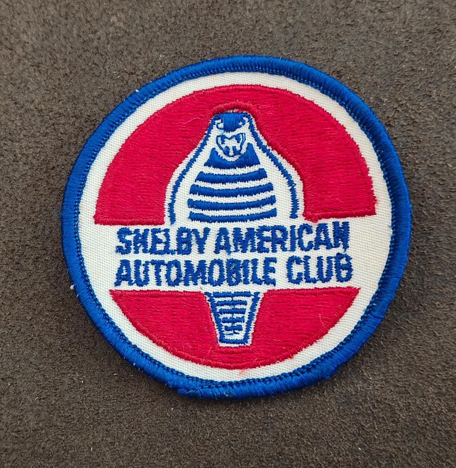 Close-up of 1990s Shelby American Automobile Club patch; blue border and embroidered text