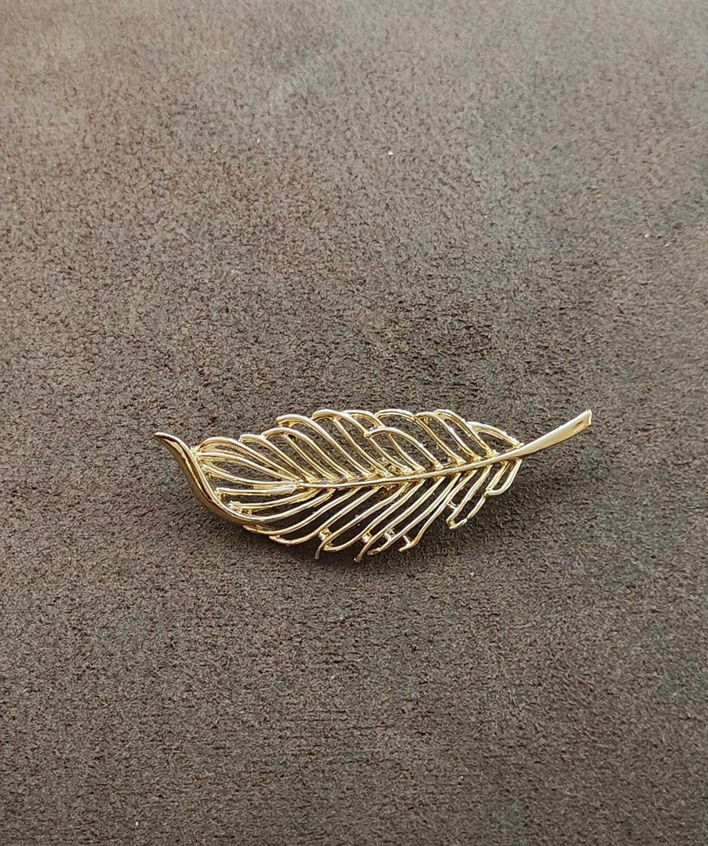Gold-tone leaf feather brooch with open filigree pattern and small tail