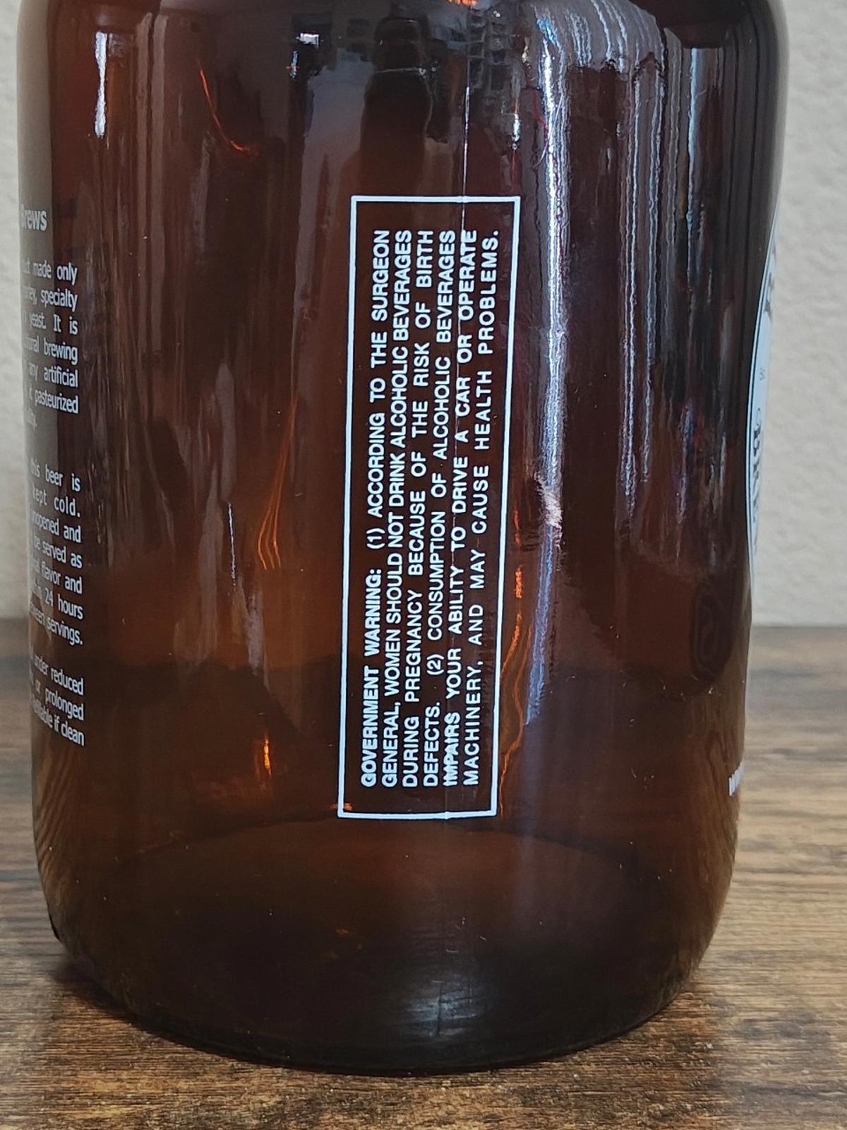 Amber glass jug close-up of white label with fine print