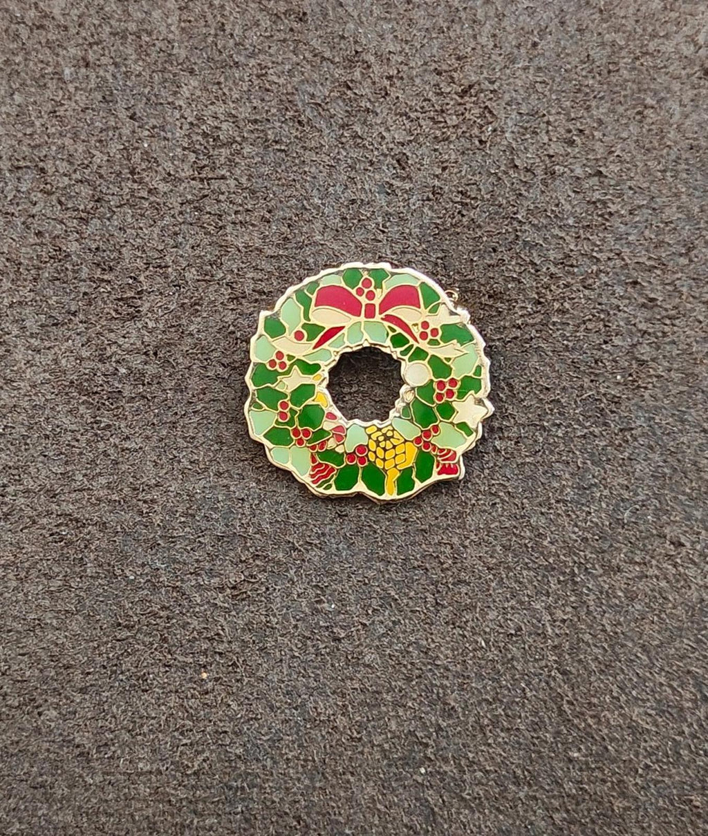Enamel Christmas wreath pin with green foliage, red berries, gold-tone outline, small bow