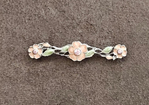 Floral bar brooch with green enamel leaves and pink rhinestone centers on silver frame