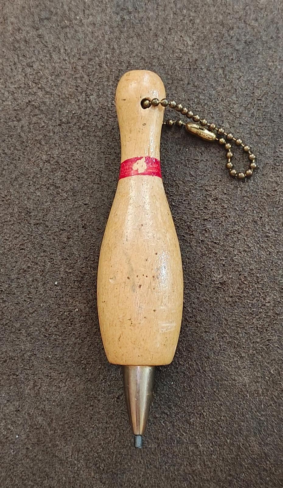 Beige wooden bowling pin mechanical pencil keychain with red band, bead chain, and point tip