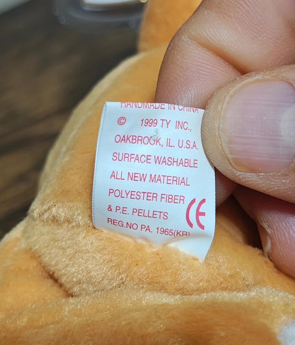 Fabric care label on brown plush bear: 1999 Ty Inc., surface washable polyester