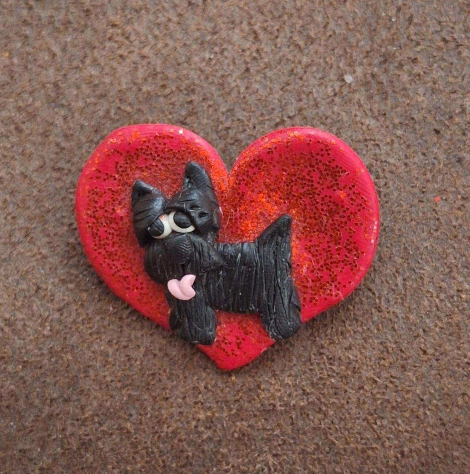 Red glitter heart pin featuring a black scottie dog with pink tongue