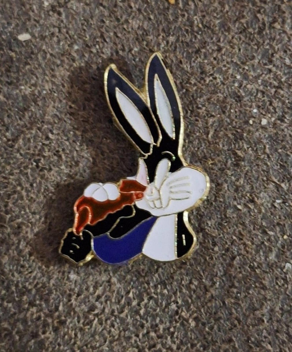Bugs Bunny enamel pin holding a carrot, blue clothing and orange carrot with gold edging