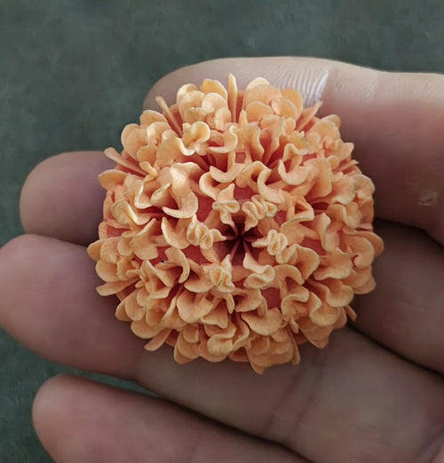 Orange pastel flower brooch with layered petal curls and central red bloom