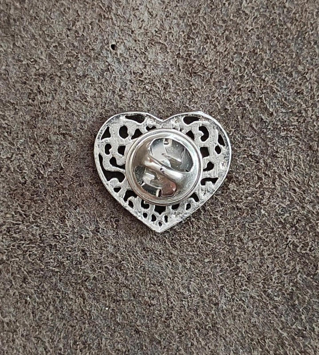 Heart cross pin back view; silver-toned heart frame with pin hardware visible