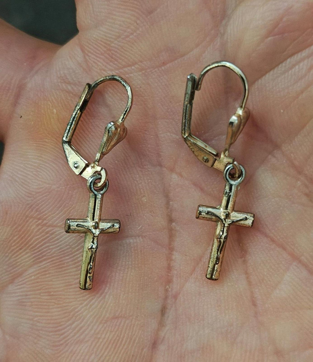 Gold-tone cross dangle earrings with heart top charm and hinged hook backs.