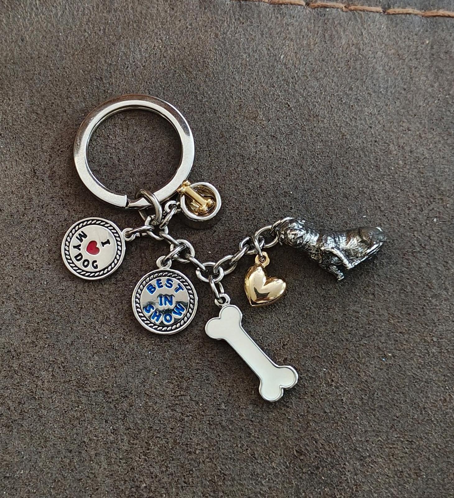 Dog charm keyring with round dog badges, white bone charm, gold bell, and metal dog figure