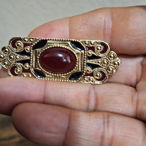 Gold-tone bar brooch pin with red lucite cabochon and dark blue enamel accents