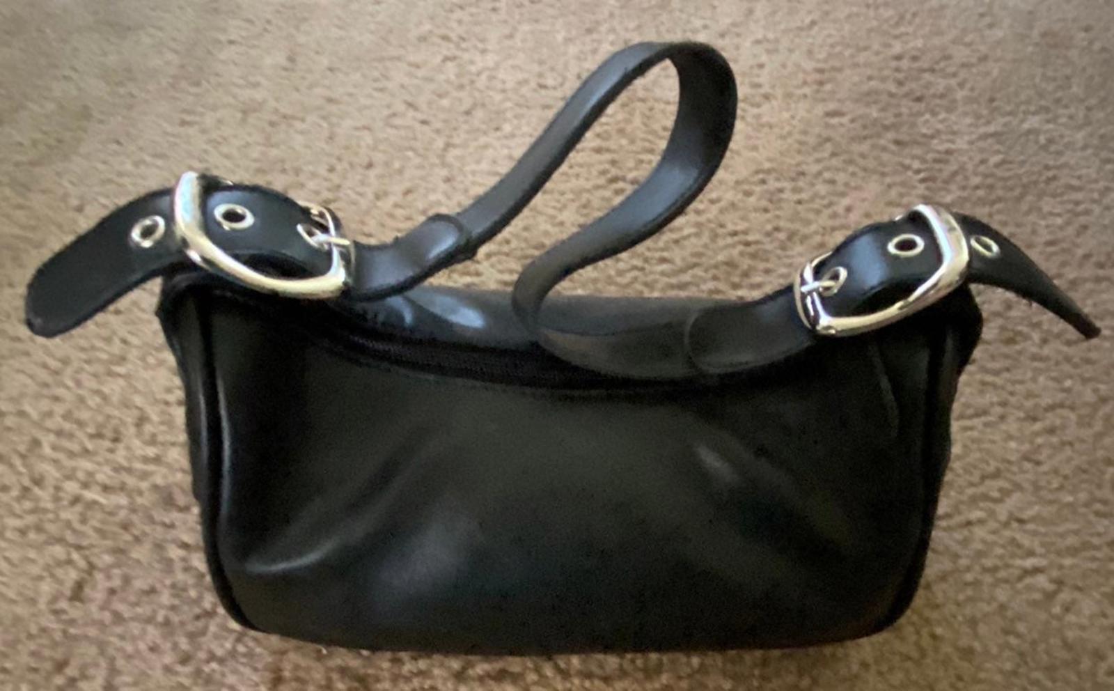 Black leather small shoulder purse with buckle strap and curved top zipper